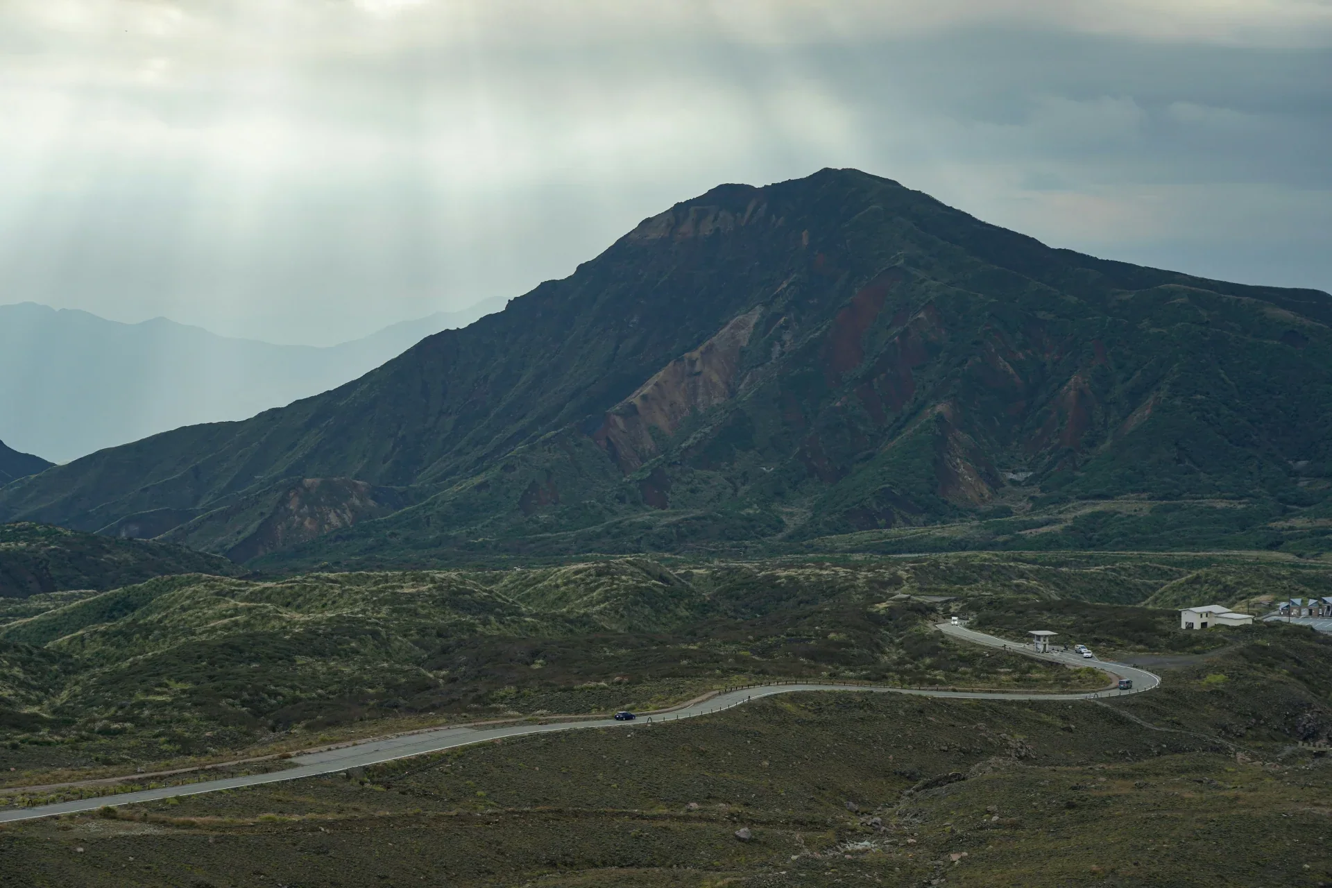 阿蘇山脈前的彎道路段,遠處山景與草坡清楚可見