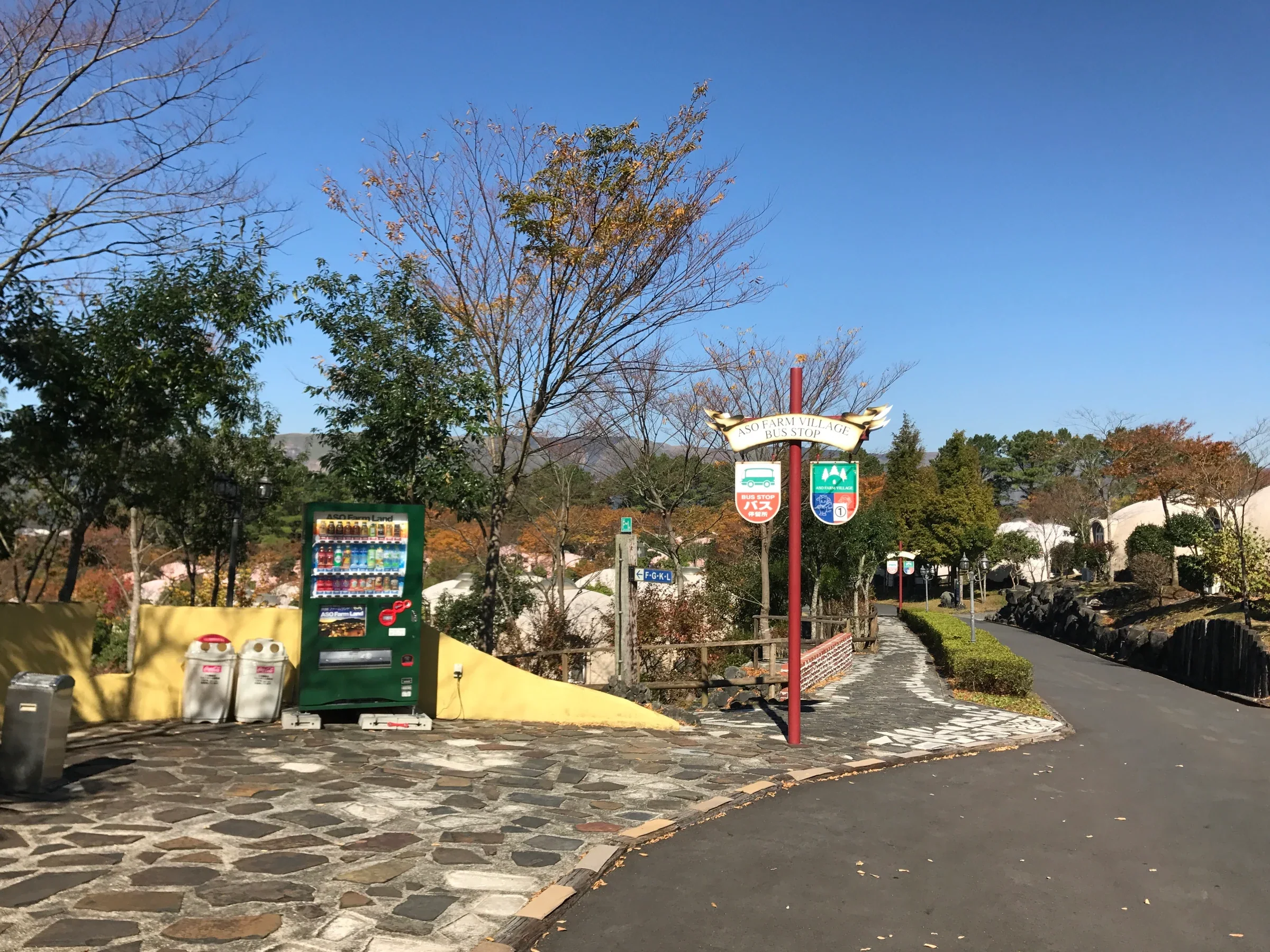 阿蘇農場樂園住宿區的巴士站與園路，遠處可見分散在綠地中的圓頂客房