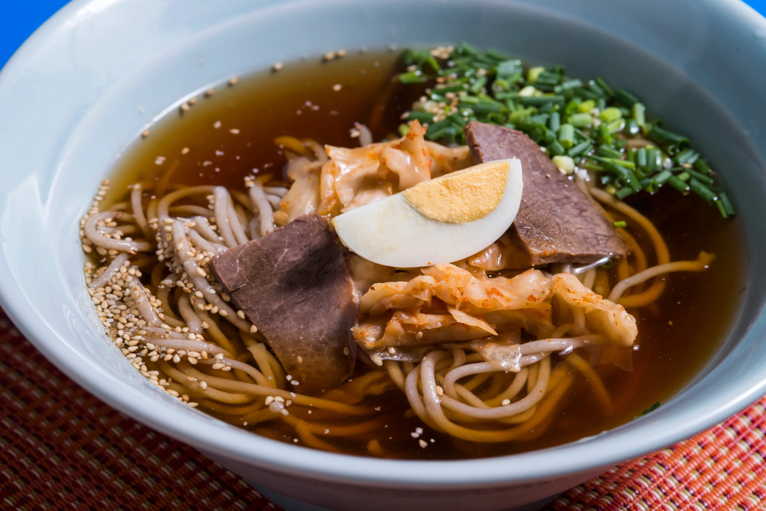 別府冷麵一碗冷湯麵,配有牛肉、泡菜、蔥花和雞蛋