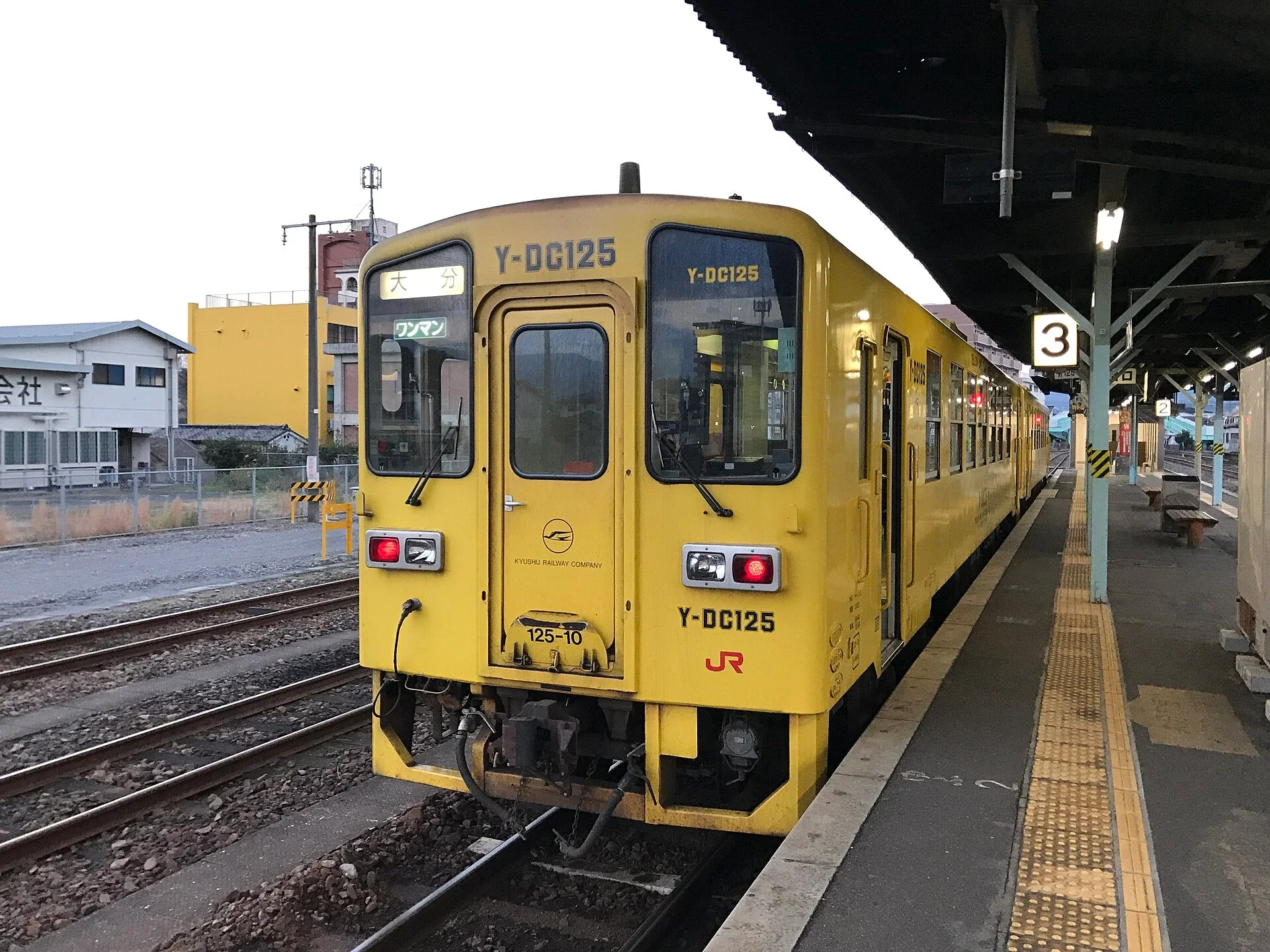 日田站月台停靠久大本線列車，車站連接市區巴士與步行街道