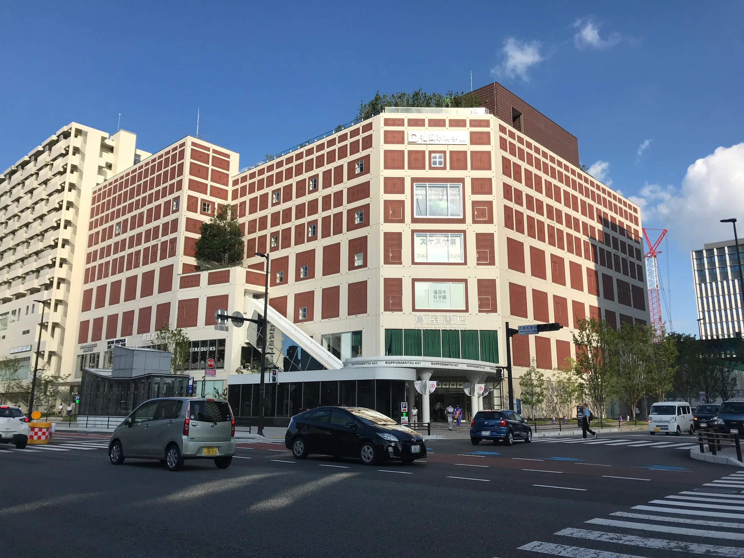 六本松421大樓外的福岡市科學館,白色與磚紅色立面朝向街口