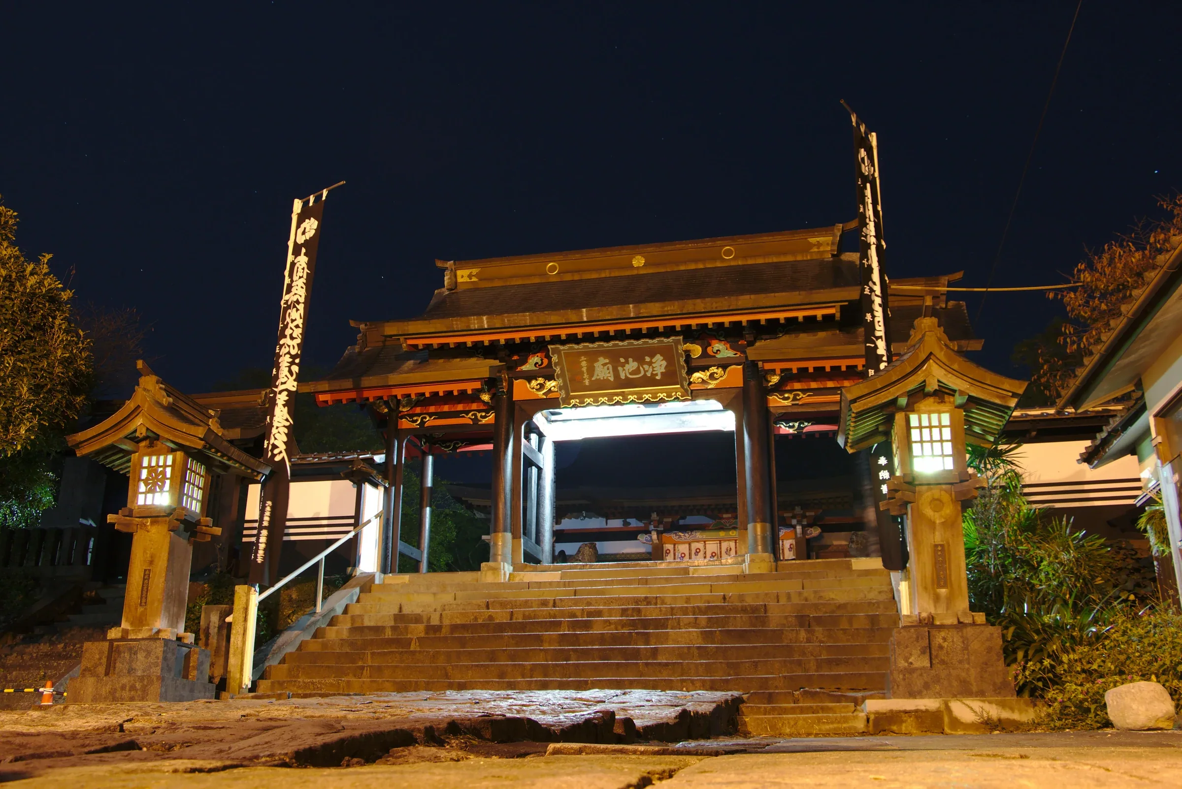 夜間燈光照亮本妙寺浄池廟門樓與前方石階