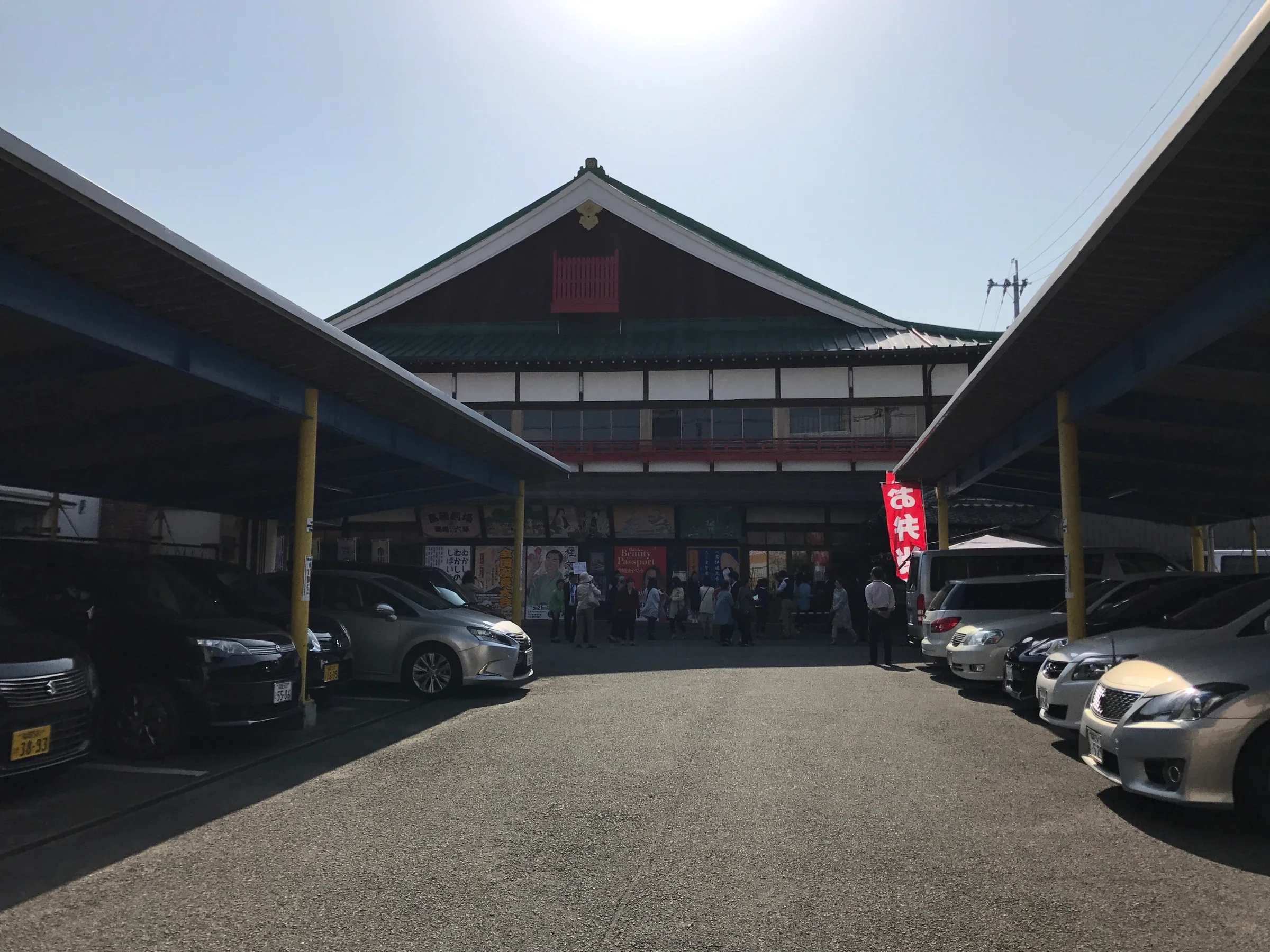 嘉穗劇場木造入口與前方停車空間，遠處有訪客