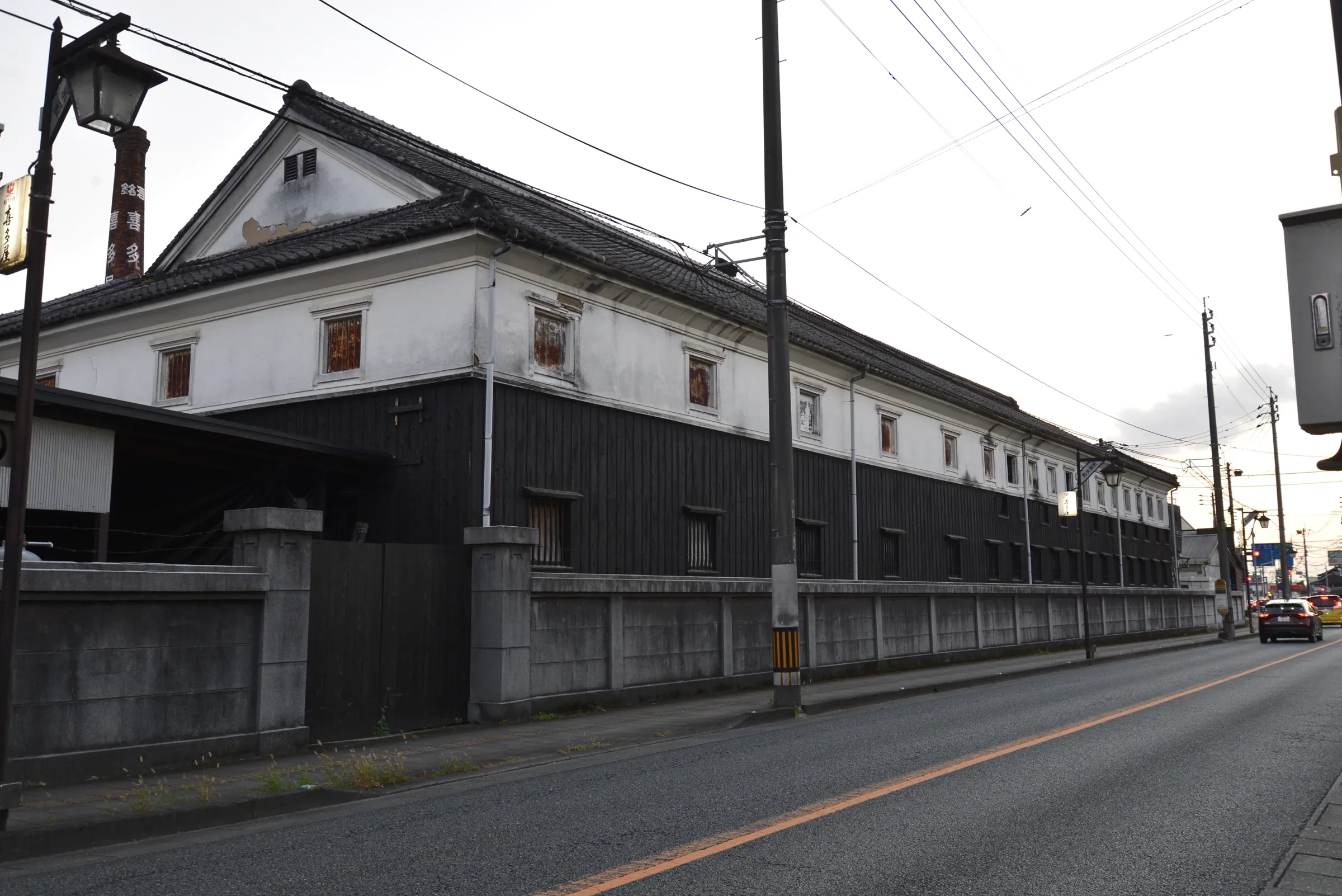 八女福島舊喜多屋白壁與黑木板長屋立面，瓦頂沿街延伸