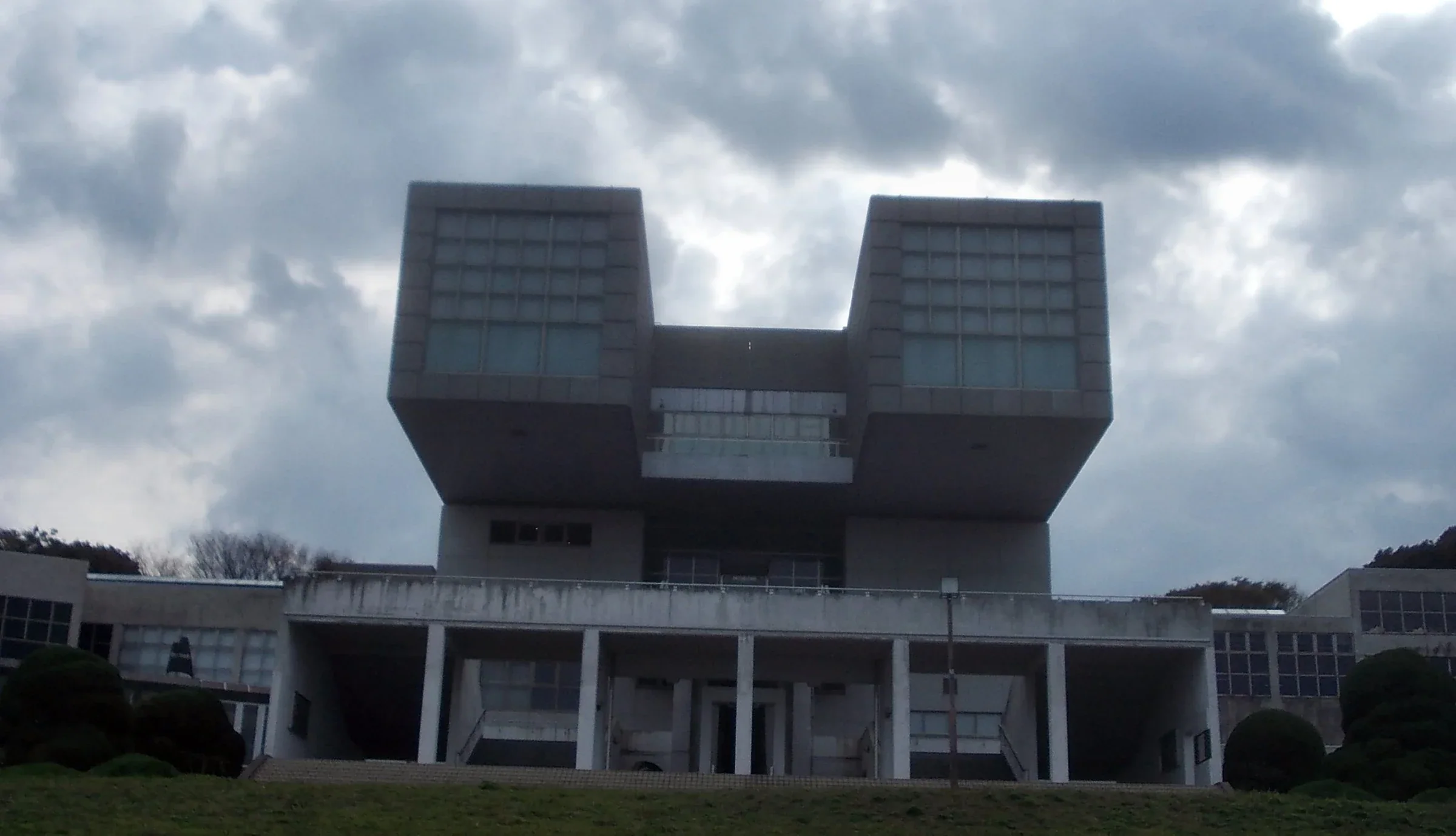 北九州市立美術館本館外觀,兩座方形量體從草坡上方伸出