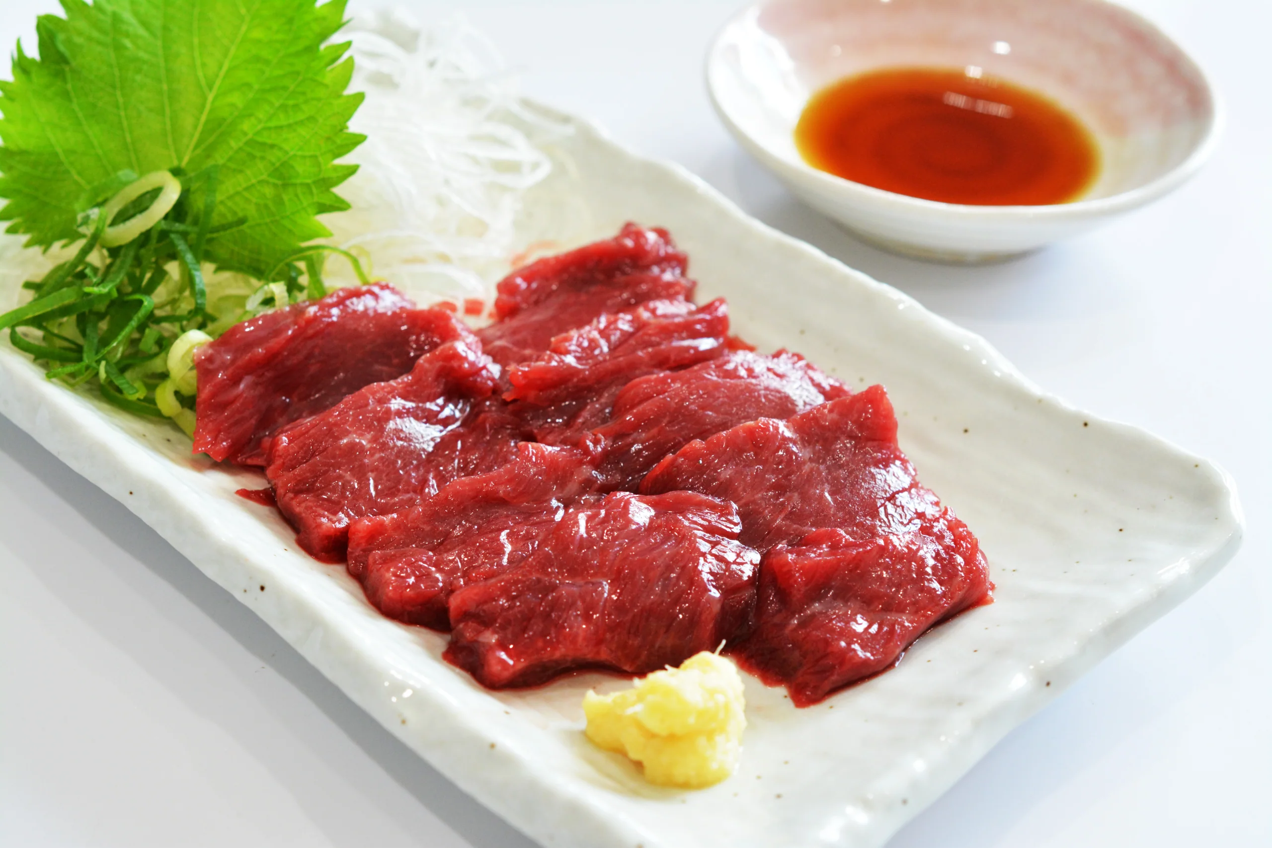 馬刺し盛合せ中的紅肉與脂紋切片,配紫蘇、蘿蔔絲和醬油