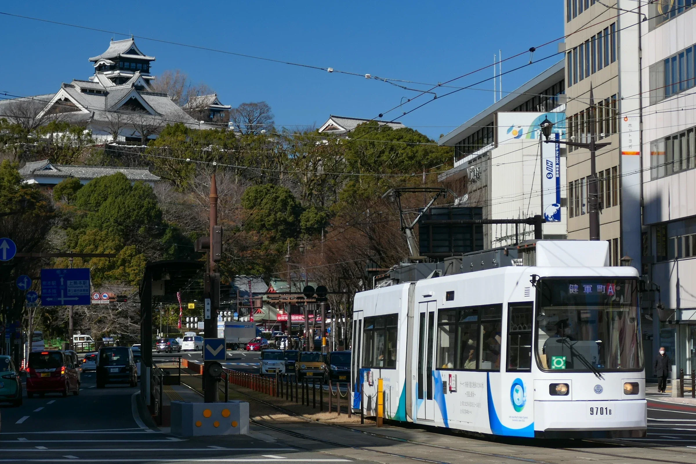 熊本市電沿街行駛，遠處可見熊本城方向