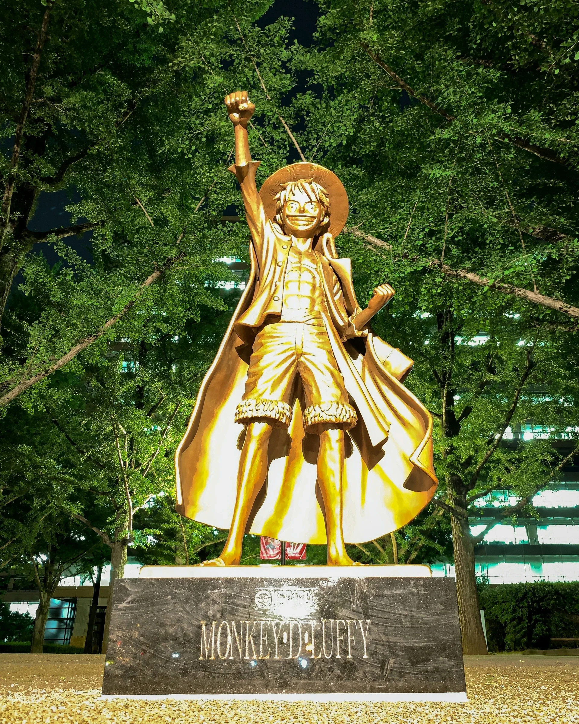 熊本縣廳前的魯夫銅像,高舉手臂站在綠樹之間