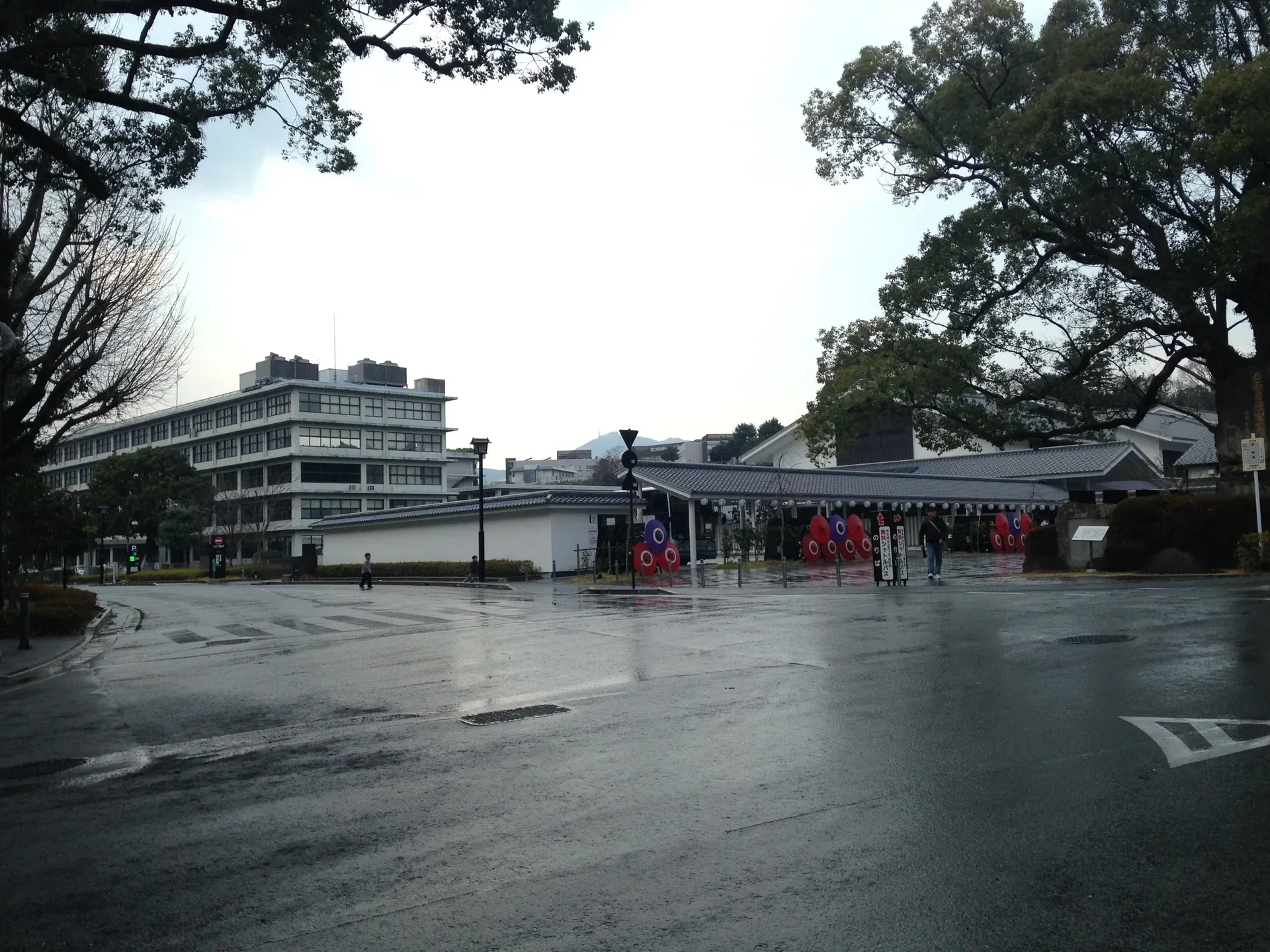雨後的櫻之馬場城彩苑入口廣場，前方是低矮的傳統風格建築