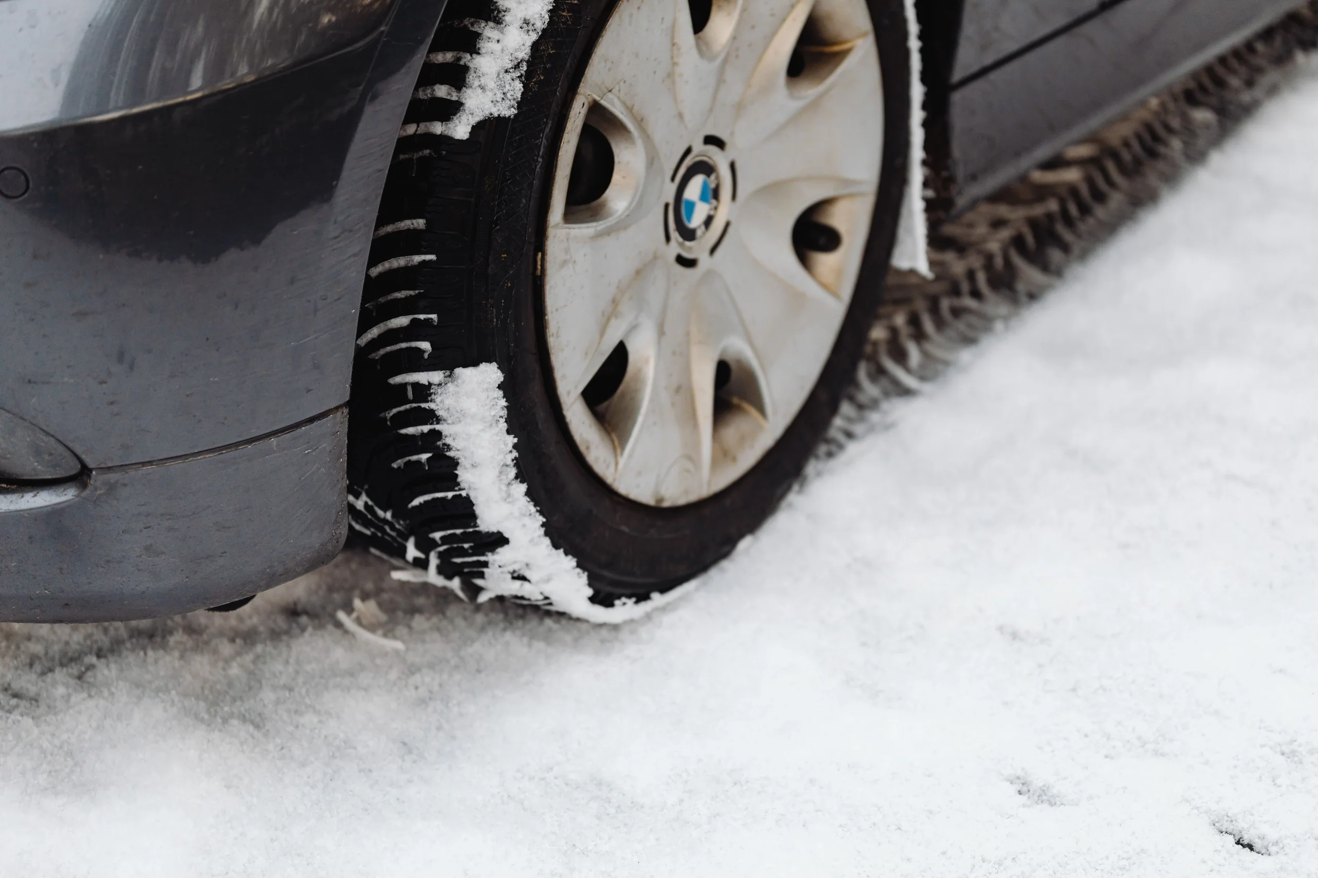 乘用車輪胎在雪地上的近照,胎面紋路沾有積雪
