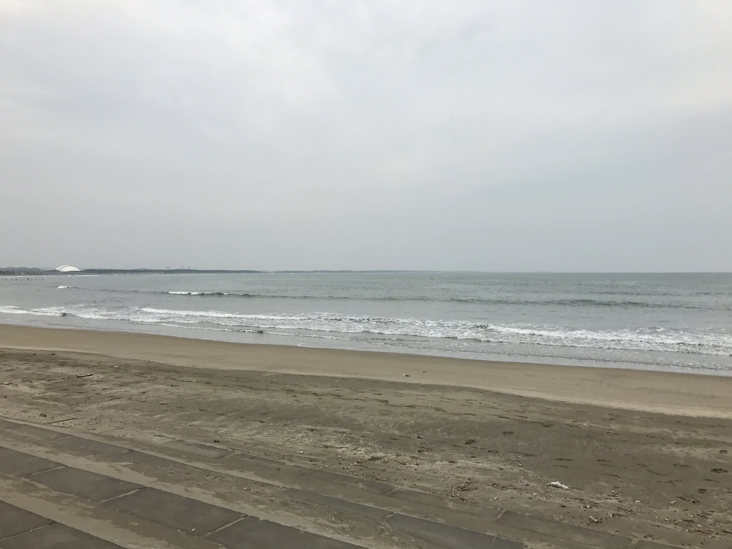 青島海水浴場的沙灘與海岸線；從 Shuttle 下車後仍需步行前往海灘