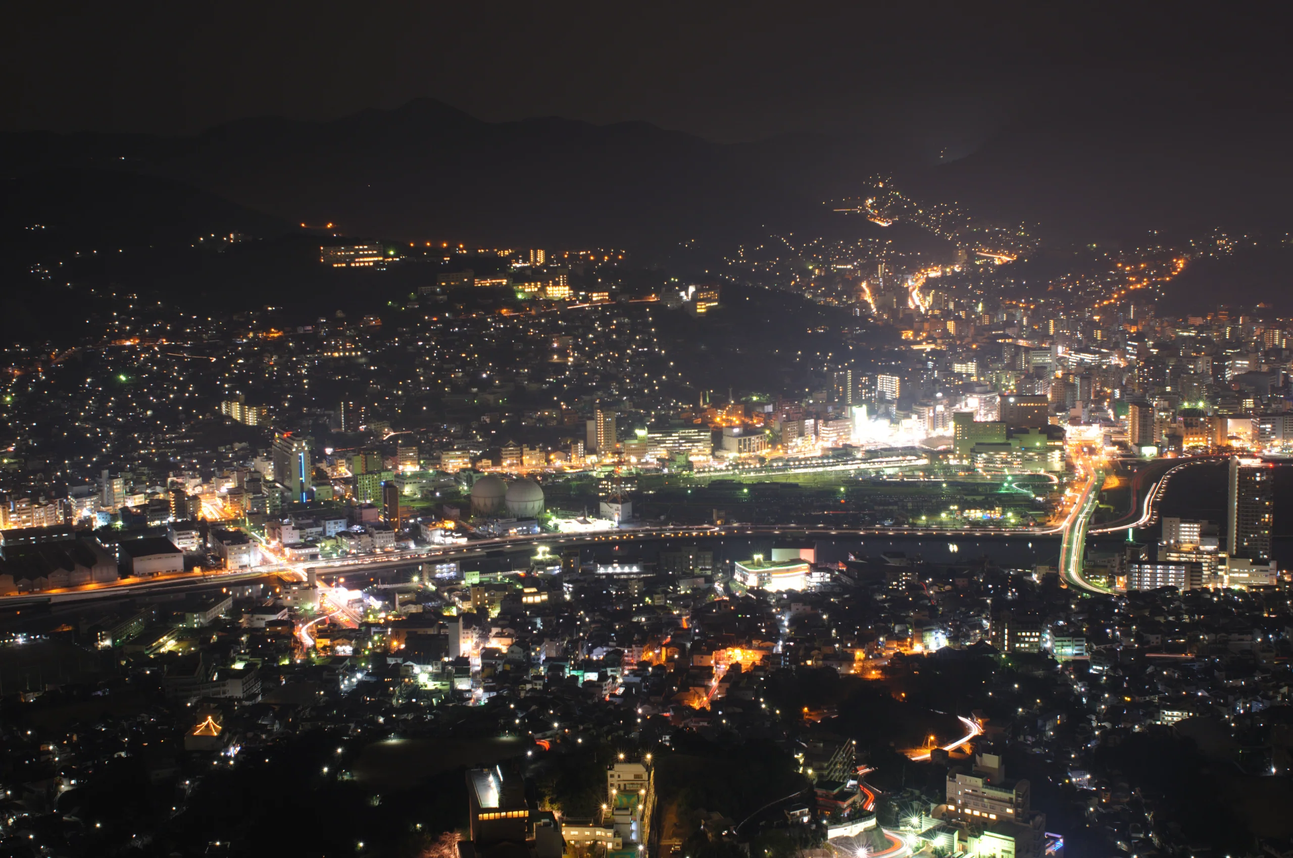 稻佐山展望台望向長崎市區的夜景,沿山坡延伸的住宅燈光映照港口