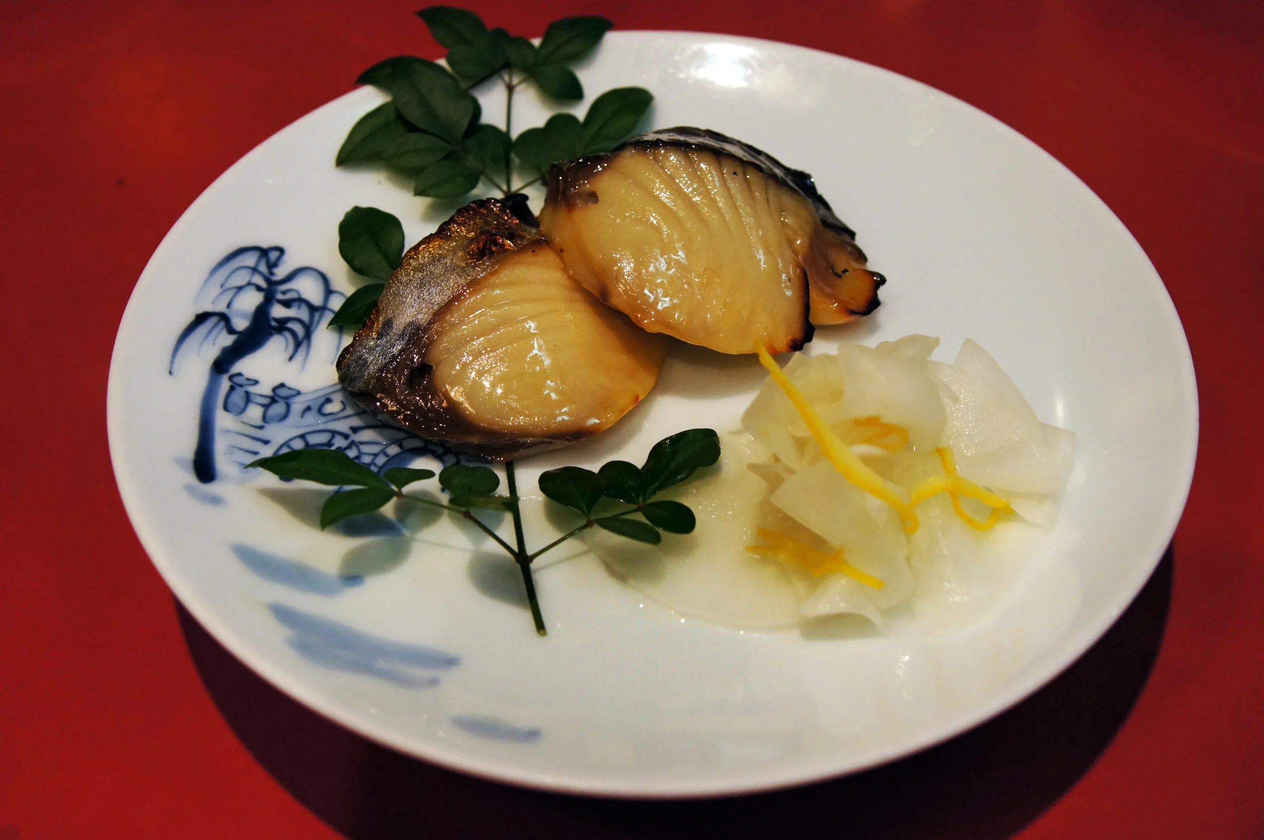 長崎卓袱浜勝的卓袱中鉢單道菜,橙黃色食材與青菜盛在藍紋白瓷盤內;並非整套宴席
