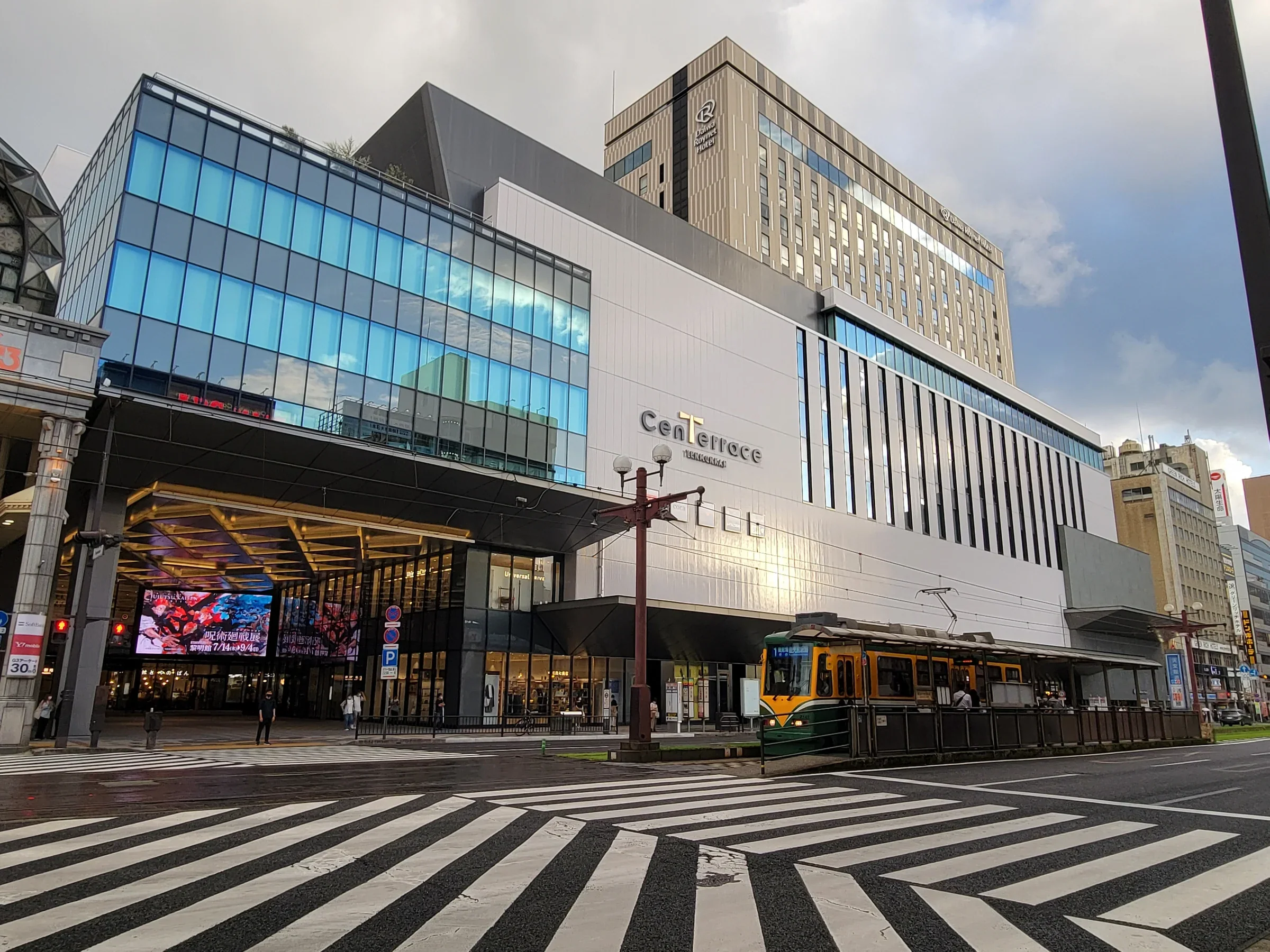 鹿兒島センテラス天文館外觀與前方市電軌道，街道設有斑馬線和商店入口