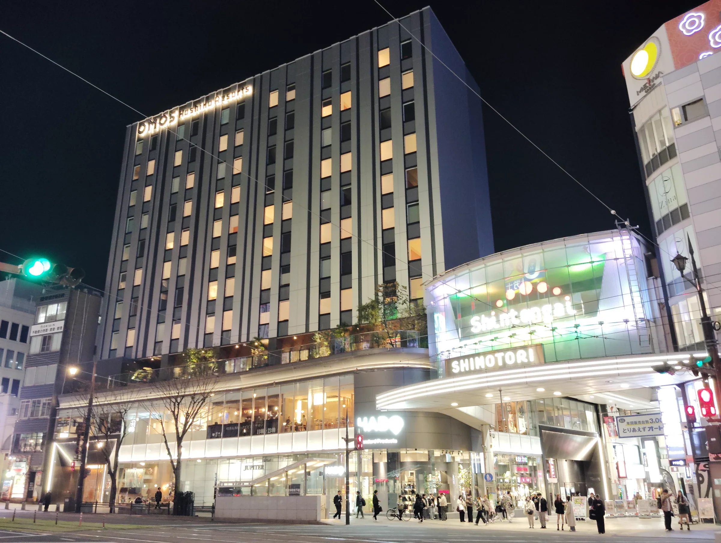 夜間的 OMO5 熊本所在大樓與下通街口,樓頂可見飯店標誌