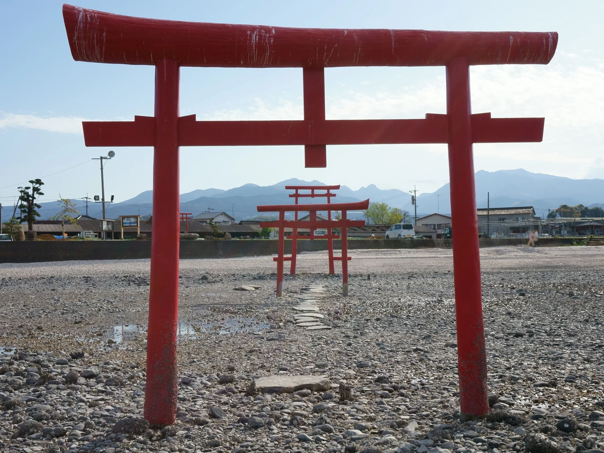退潮時的大魚神社海中鳥居與遠處多良岳，畫面沒有行人