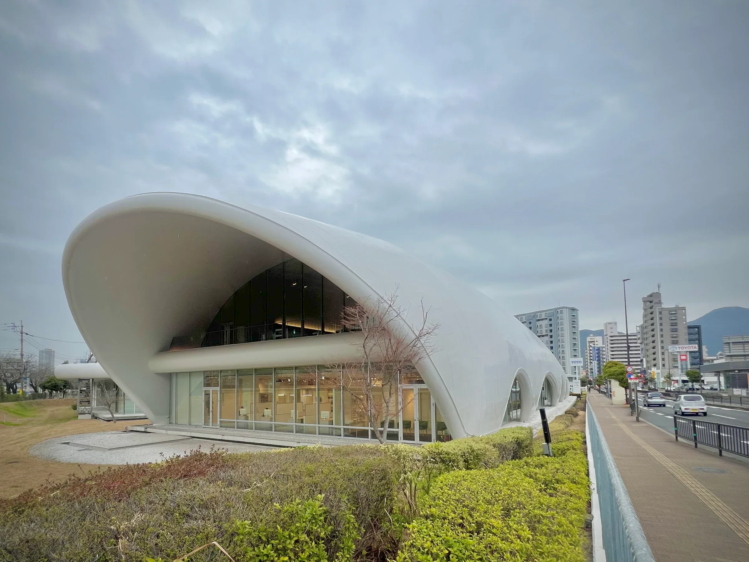TOTO Museum白色曲線立面、大片玻璃與路旁植栽，2026年2月館舍實景，非山田紗子作品