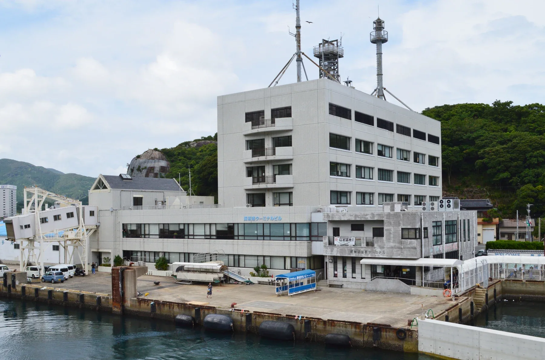從海面望向對馬嚴原港,渡輪碼頭與港邊街區沿岸展開